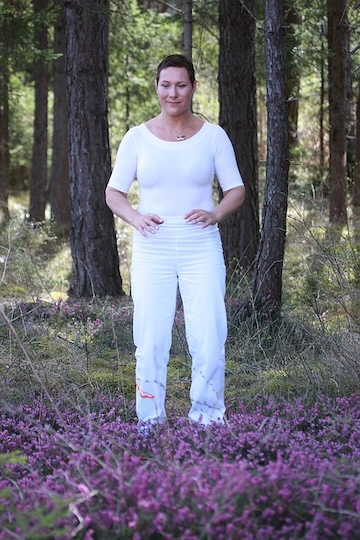 Woman practicing qigong in a forest