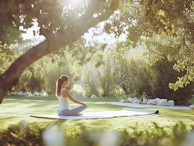 A woman sitting in quiescent tai chi qigong meditation in a garden at dawn.